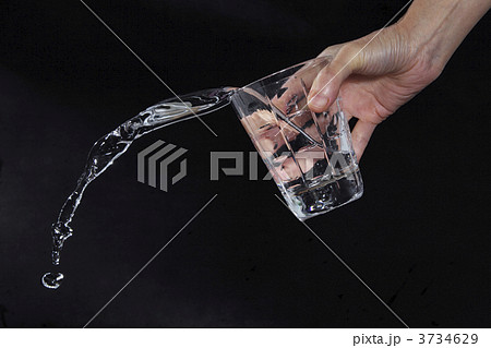 水 こぼれる 手 グラスの写真素材