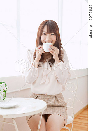 女性 ミニスカート 笑顔 座る 女の子 屋内 大学生 専門学生 学生の写真素材