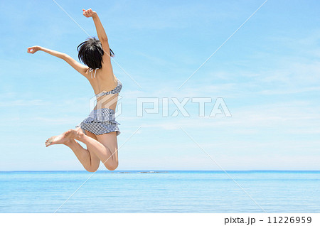 水着 ビキニ 飛び上がる ジャンプの写真素材