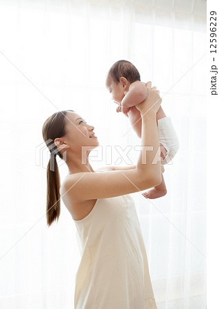 たかいたかい 乳幼児 赤ちゃん 白バック 笑顔 高い高いの写真素材
