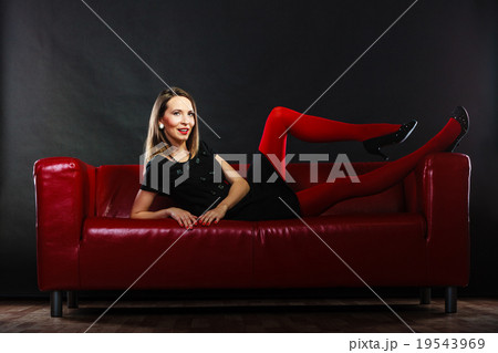 Fashion woman in red pantyhose on couch - Stock Photo [72617681