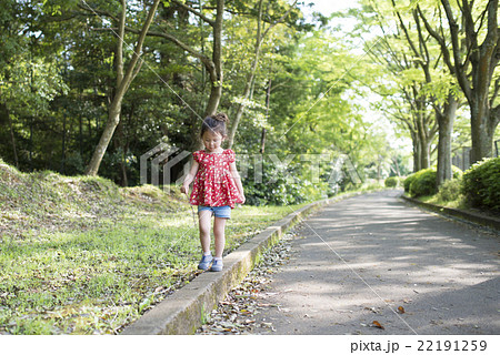 縁石の上を歩く女の子の写真素材