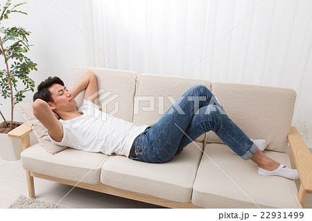 男性 ソファー 寝る 昼寝の写真素材