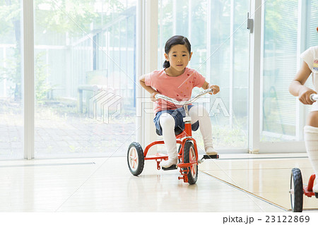 女の子 幼稚園児 三輪車 乗るの写真素材