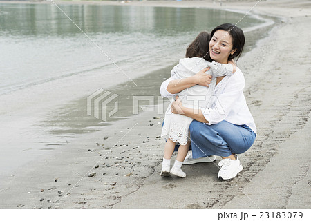 親子 海 ハグ 抱きしめるの写真素材