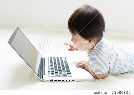 赤ちゃん ノートパソコン 興味 触るの写真素材