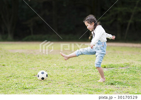 サッカー 裸足 サッカーボール 女の子の写真素材