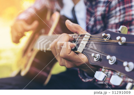 ギター 演奏 座る シャツの写真素材