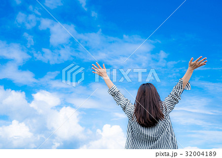 空に向かって両手を広げる女性の写真素材 3041