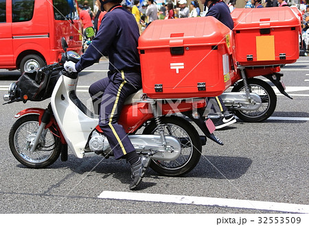 バイク 赤いバイク 郵便配達 郵便局の写真素材