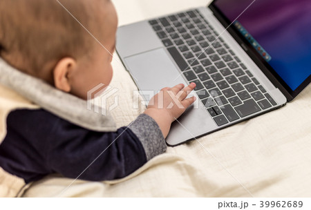 赤ちゃん ノートパソコン 興味 触るの写真素材