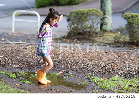 子供 女の子 水たまり 長靴の写真素材