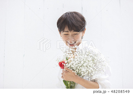 女性 花束 抱える 花の写真素材