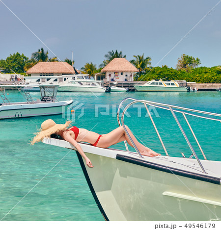 A woman in a trendy bikini lounging on a beach towel. Generative