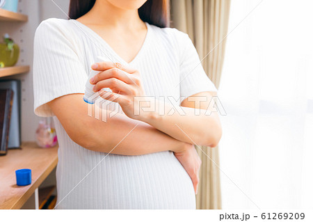痒み止め薬を使う妊婦の写真素材