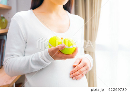テニスボールを持つ妊婦 マッサージ 出産準備 いきみ逃しの写真素材