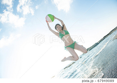 ビーチボール水着でジャンプ 水着の女性がビーチボールを打ってジャンプしている3d ...