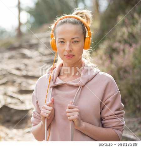 女性 女の子 ヘッドフォン パーカー 音楽の写真素材