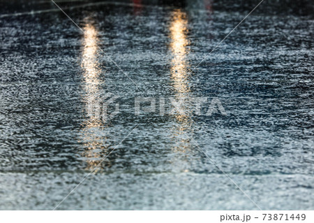水たまり 雨 アスファルト 道路の写真素材