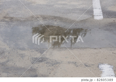 水たまり 雨 アスファルト 道路の写真素材