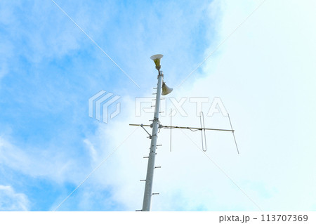青空に映える町内放送のスピーカーと防災行政無線